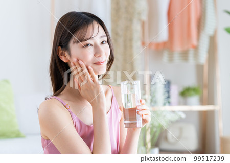 一個年輕的女人喝礦泉水 99517239