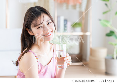 一個年輕的女人喝礦泉水 99517243