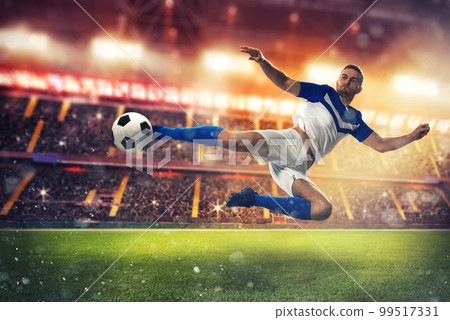 Soccer striker hits the ball with an acrobatic kick 99517331
