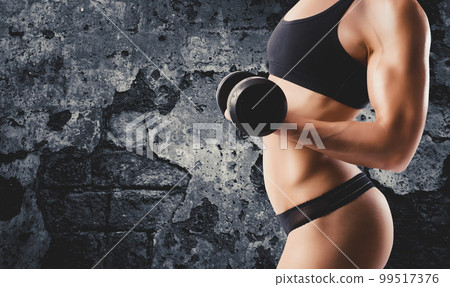 Athletic woman training biceps on grunge background 99517376