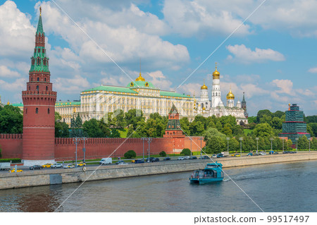 View of Kremlin with Vodovzvodnaya tower, Grand Kremlin Palace from repaired Bolshoy Kamenny Bridge in Moscow city on sunny summer day. Cruise ship sails on the Moscow river 99517497