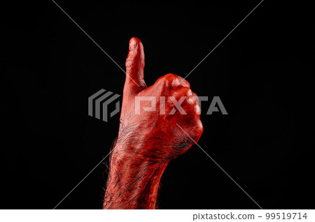 Male hand stained with blood on a black background holds the thumb up. Male hand stained with blood on a black background holds the thumb up. 99519714