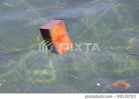 A rusty empty can floating in the sea 99519783