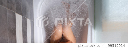 Naked woman sits in bathtub under shower top view 99519914