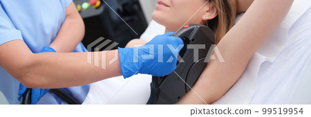 Woman undergoes hair removal procedure with photoepilator or laser hair removal of armpits in salon Woman undergoes hair removal procedure with photoepilator or laser hair removal of armpits in salon 99519954