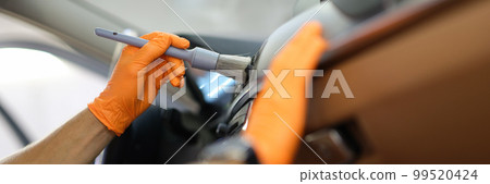 Master repairman cleans the car air conditioner with brush in workshop closeup 99520424