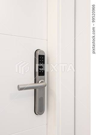 Entrance white wooden door with an electronic lock for the security of the apartment. On the lock there are buttons with numbers for entering the code. Chrome metal lock. Entrance white wooden door with an electronic lock for the security of the apartment. On the lock there are buttons with numbers for entering the code. Chrome metal lock. 99520966