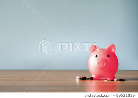 Piggy Bank and a few coins on gray background. The concept of saving less saving money piggy bank and financial planning concept, broke and poor copy space Piggy Bank and a few coins on gray background. The concept of saving less saving money piggy bank and financial planning concept, broke and poor copy space 99521039