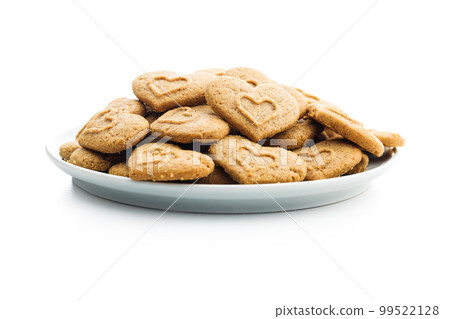 Sweet gingerbread hearts on plate isolated on white background. 99522128
