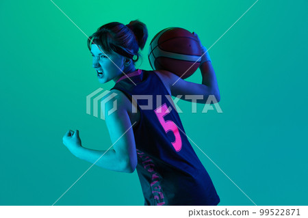 Sportive ambitions and motivation. Teen girl, basketball player posing with ball isolated over gradient green background in neon light. Concept of professional sport and hobby 99522871