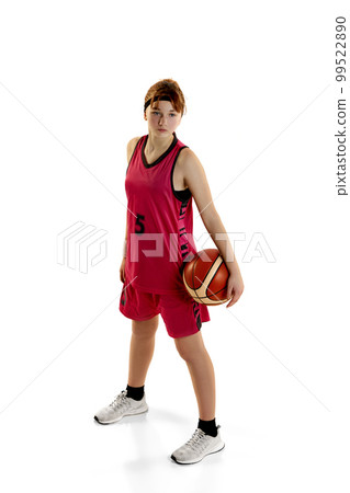 Popular game. Teen girl, basketball player in uniform posing with ball isolated over white studio background. Concept of professional sport and hobby 99522890
