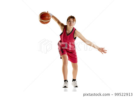 Portrait of teen girl, basketball player in uniform with ball, in motion, training isolated over white studio background. Concept of professional sport and hobby 99522913