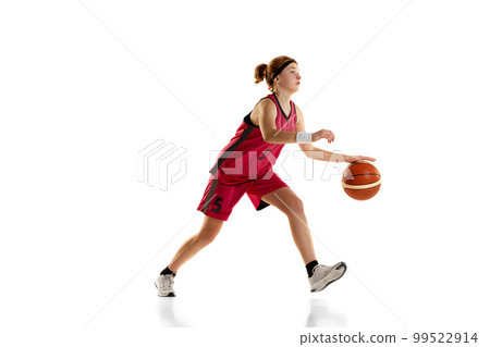 Dynamic portrait of teen girl, basketball player dribbling ball, playing isolated over white studio background. Concept of professional sport and hobby 99522914