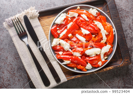 Esgarraet Cod salad with grilled red peppers, garlic and olive oil closeup on the plate. Horizontal top view Esgarraet Cod salad with grilled red peppers, garlic and olive oil closeup on the plate. Horizontal top view 99523404