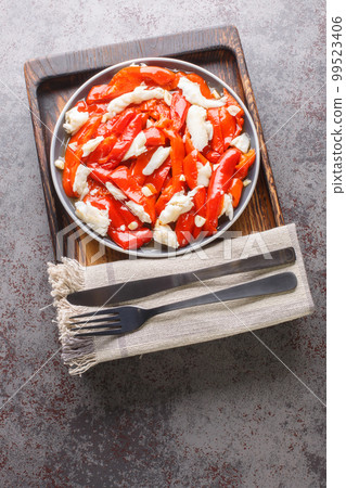 Red bell pepper and cod fish esgarraet tapas from Spain closeup on the plate. Vertical top view Red bell pepper and cod fish esgarraet tapas from Spain closeup on the plate. Vertical top view 99523406