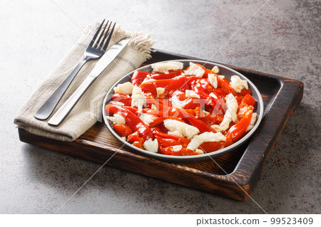 Esgarraet is a typical dish from the Valencian community in Spain it consists of grilled red pepper salad, cured cod, garlic, olive oil closeup on the plate. Horizontal Esgarraet is a typical dish from the Valencian community in Spain it consists of grilled red pepper salad, cured cod, garlic, olive oil closeup on the plate. Horizontal 99523409