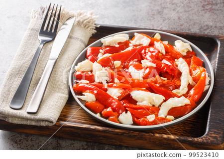 Esgarraet Cod salad with grilled red peppers, garlic and olive oil closeup on the plate. Horizontal Esgarraet Cod salad with grilled red peppers, garlic and olive oil closeup on the plate. Horizontal 99523410