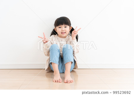 smiling child sitting on the floor 99523692