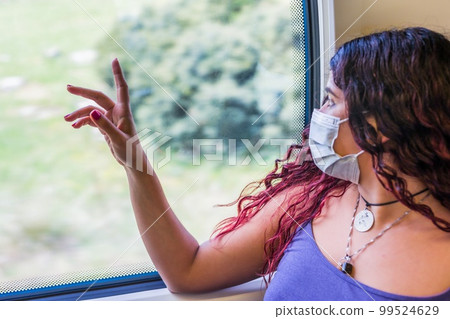 Train transport traveler passenger looking with emotion at window. Young venezuelan latin Tourist Train transport traveler passenger looking with emotion at window. Young venezuelan latin Tourist 99524629