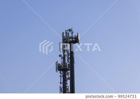Telecommunications tower with cellular antennas and repeaters against a clear blue sky Telecommunications tower with cellular antennas and repeaters against a clear blue sky 99524731