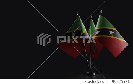 Small national flags of the Saint Kitts and Nevis on a black background 99525576