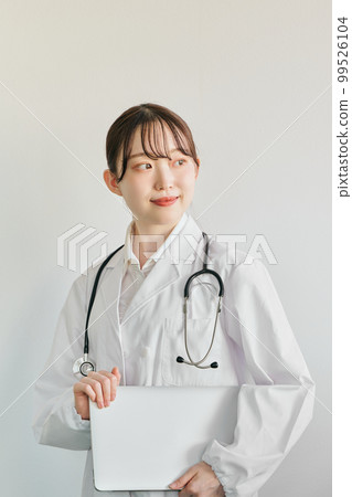 Young female doctor standing with a computer Young female doctor standing with a computer 99526104