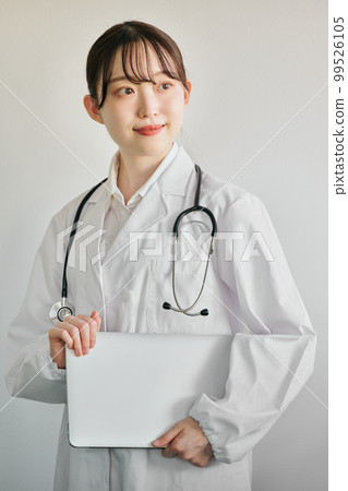 Young female doctor standing with a computer Young female doctor standing with a computer 99526105