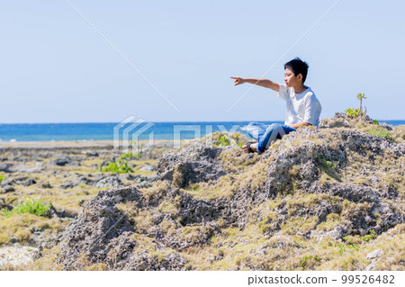A boy pointing at the sea of Okinawa A boy pointing at the sea of Okinawa 99526482