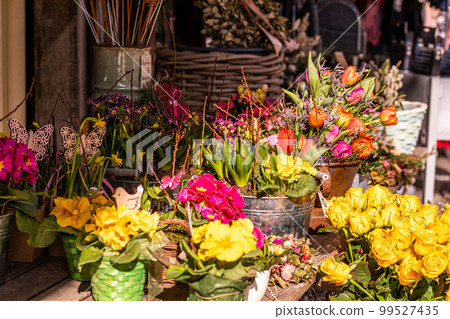 Different flowers and seedlings near the florist flower shop entrance, spring time, easter concept Different flowers and seedlings near the florist flower shop entrance, spring time, easter concept 99527435