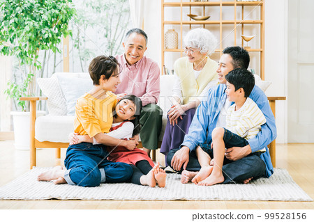 Three-generation family relaxing in the living room Three-generation family relaxing in the living room 99528156