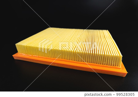 An air filter that isolates dust and dirt before entering a car's engine. New yellow on black background 99528305