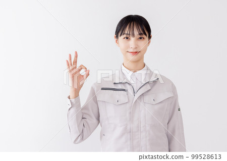 A woman in work clothes giving OK A woman in work clothes giving OK 99528613