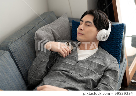 A man falling asleep while listening to music A man falling asleep while listening to music 99529384