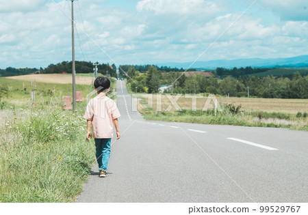 boy walking on a straight road boy walking on a straight road 99529767