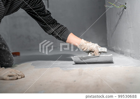 work with trowel on floor and wall in new room in building work with trowel on floor and wall in new room in building 99530688
