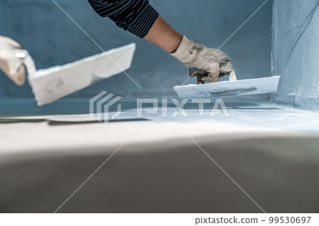 work with trowel on floor and wall in new room in building work with trowel on floor and wall in new room in building 99530697