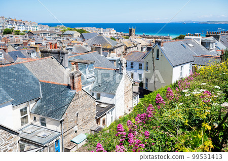 View of rooftops in St Ives, west Cornwall, South West England. Beautiful blue sea on the background. Selective focus View of rooftops in St Ives, west Cornwall, South West England. Beautiful blue sea on the background. Selective focus 99531413