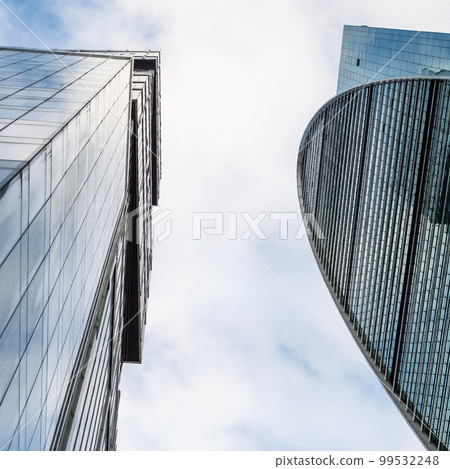 bottom view of glass skyscrapers on cloudy day 99532248