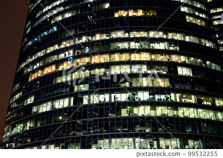 facade of glass tower with illuminated windows 99532255