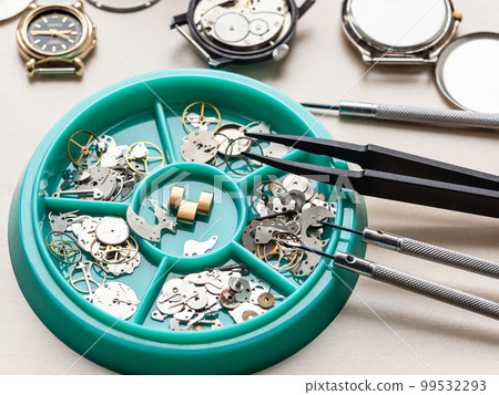 clock spare parts in tray on wooden table clock spare parts in tray on wooden table 99532293