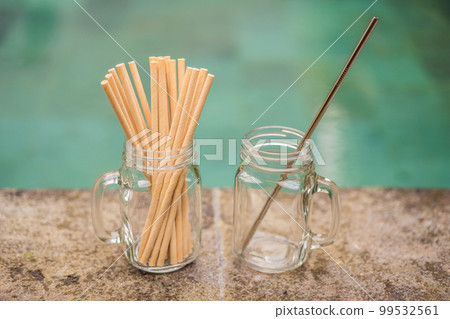 Steel drinking vs disposable straws on pool background. Zero waste concept 99532561