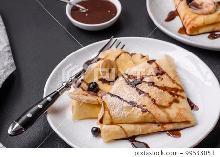 Delicious fresh baked pancakes with honey and fruits on a concrete background Delicious fresh baked pancakes with honey and fruits on a concrete background 99533051