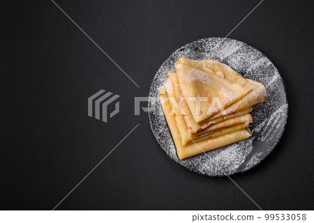 Delicious fresh baked pancakes with honey and fruits on a concrete background 99533058