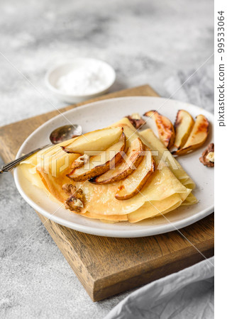 Delicious fresh baked pancakes with honey and fruits on a concrete background 99533064