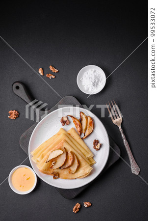 Delicious fresh baked pancakes with honey and fruits on a concrete background 99533072