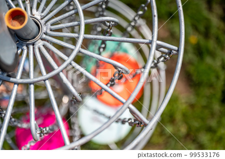Top view of a golf basket chains with discs blurred below Top view of a golf basket chains with discs blurred below 99533176