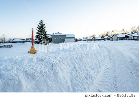 Fire hydrant with a locator protruding from a snow back along a residential street. Fire hydrant with a locator protruding from a snow back along a residential street. 99533192