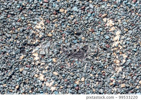 Macro of hail damage on a shingle residential roof circled with a chalk outline during a home inspection. 99533220
