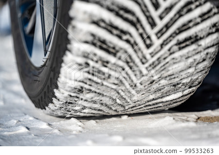 Closeup selective focus on snow packed in an all-weather tire tread. 99533263
