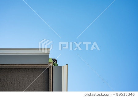 Metal gutters be installed on a residential buildings with two sections coming together for a 90 degree connection.  99533346